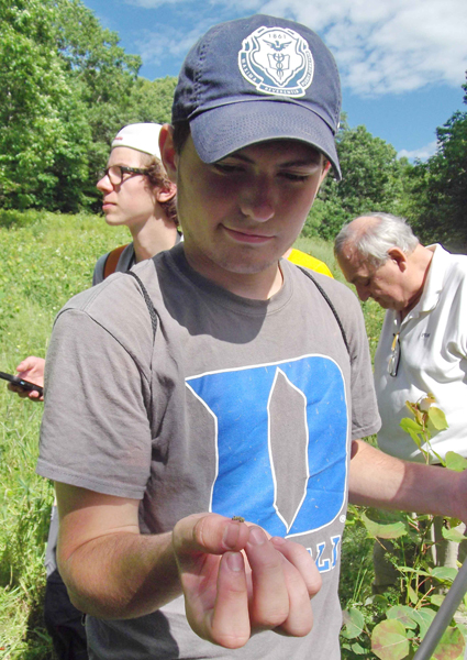 Will Ackerman With a Tiny Monarch Butterfly Caterpillar on His Thumb (Deb Kure)