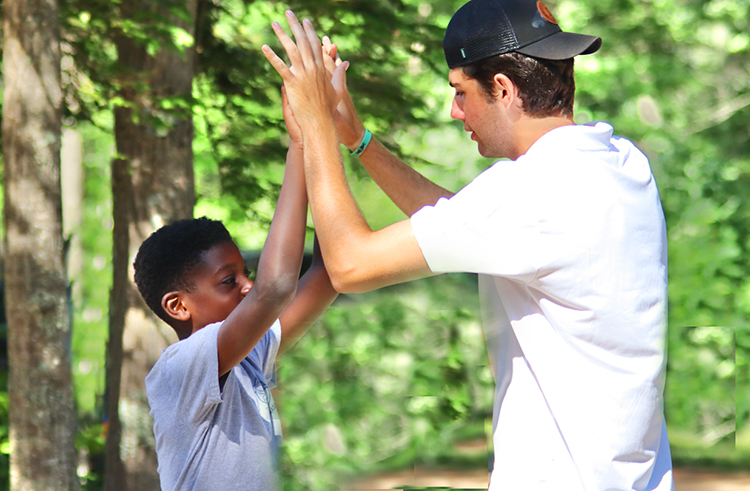 Pemi counselor giving high five to camper