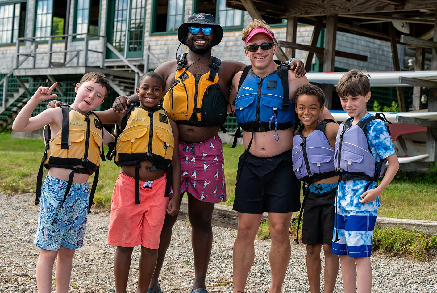 Campers and staff wearing life jackets, smiling